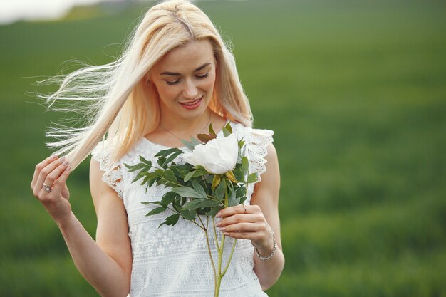 Free photo woman in elegant dress standing in a summer field