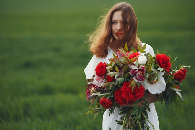 Woman in elegant dress standing in a summer field