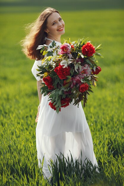 Woman in elegant dress standing in a summer field