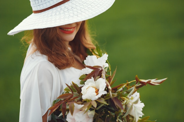 Free photo woman in elegant dress standing in a summer field