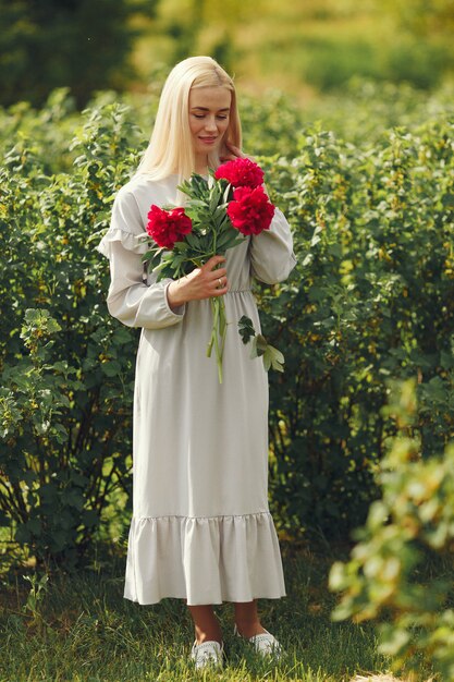 Woman in elegant dress standing in a summer field