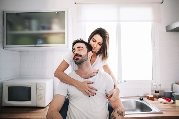 Woman embracing man in kitchen