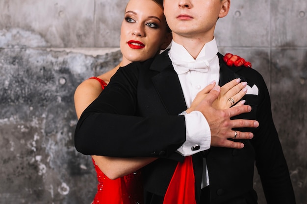 Free photo woman embracing man in suit from back