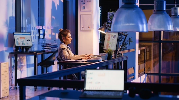 Free photo woman employee looking at startup analytics on pc