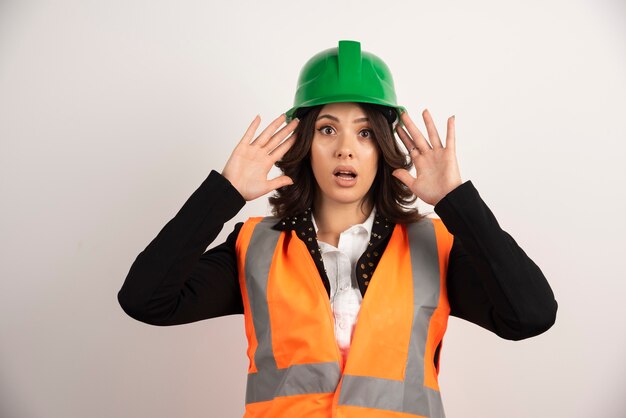 Woman engineer acting surprised on white