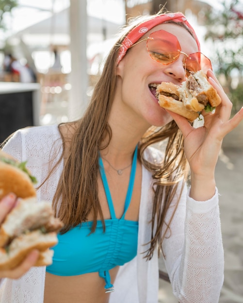 Woman enjoying a burger by the beach