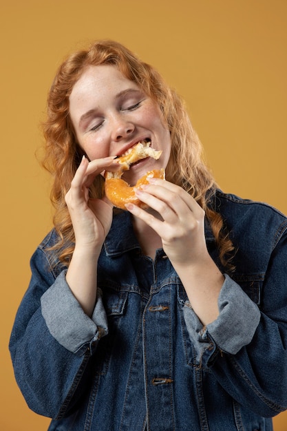 Free photo woman enjoying eating a donut