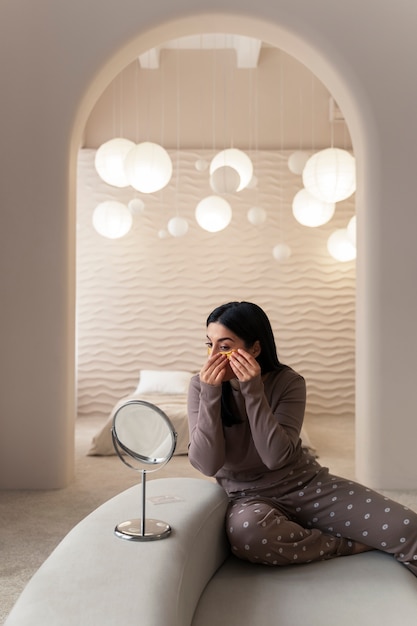 Woman enjoying her beauty routine with golden eye patches