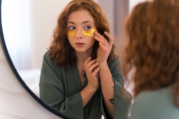 Woman enjoying her beauty routine with golden eye patches