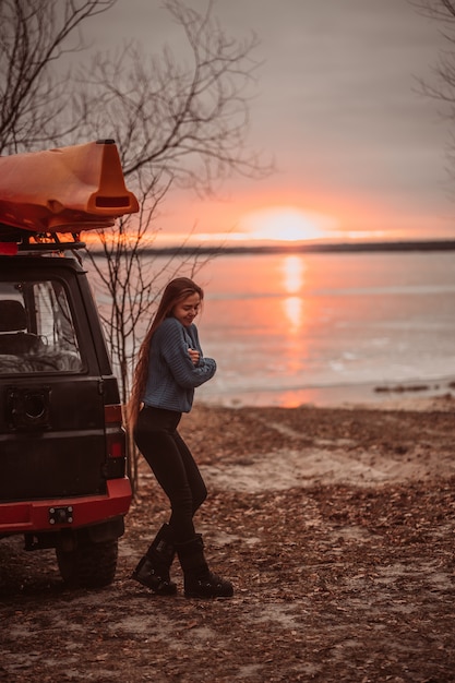 Woman enjoying time relaxing by the beautiful lake at sunrise