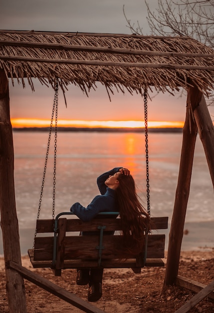 Woman enjoying time relaxing by the beautiful lake at sunrise