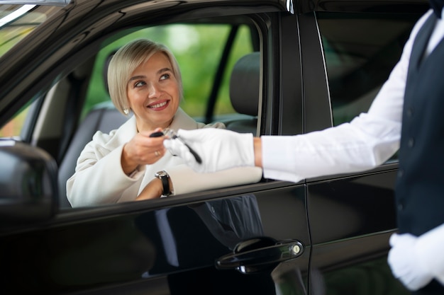 Free photo woman exchanging car keys with parking valet