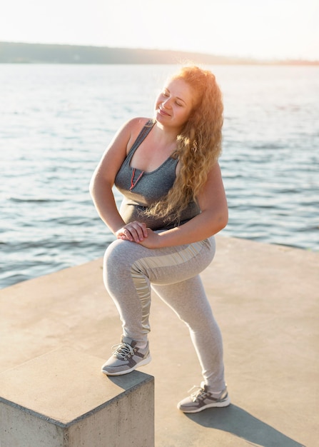 Woman exercising by the lake