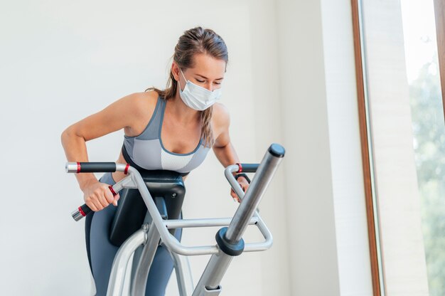 Woman exercising at the gym with mask and equipment