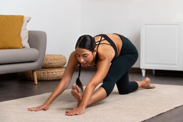 Woman exercising indoors full shot