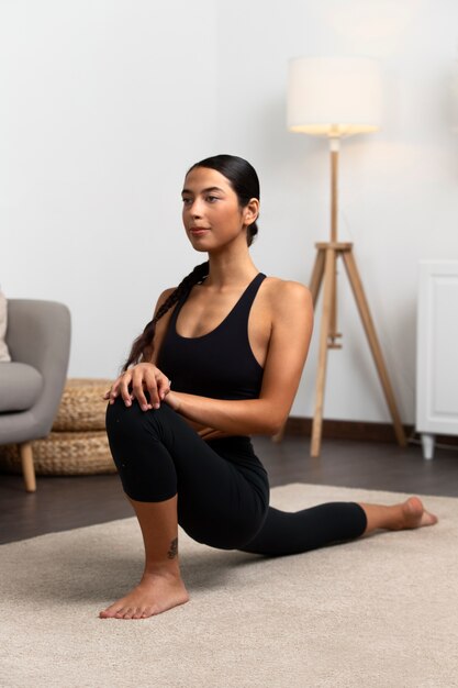 Woman exercising indoors full shot