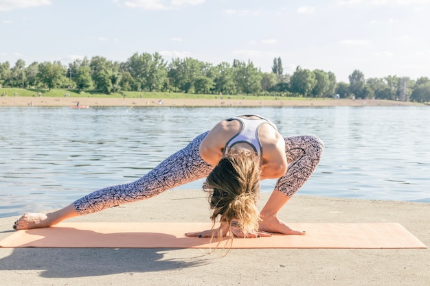 Woman exercising and meditating at river