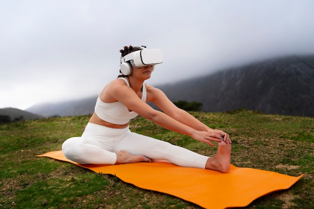 Free photo woman exercising outdoors in nature with vr glasses