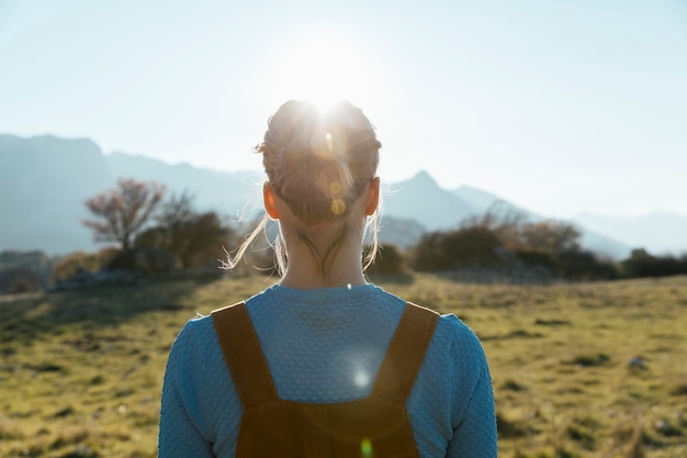 Free photo woman facing sun in nature