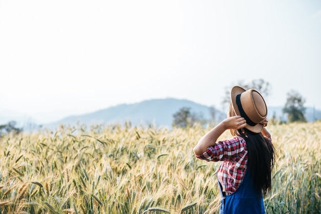 Free photo woman farmer with barley field harvesting season