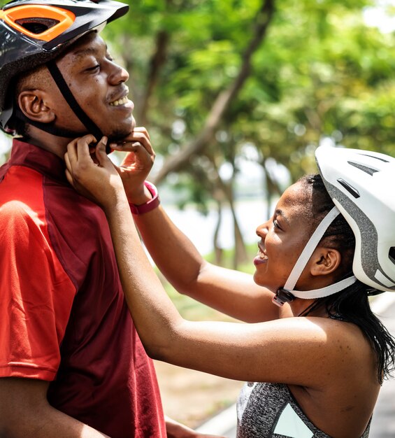 Woman fastens a bike helmet for her boyfriend