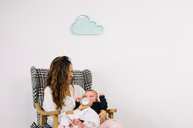 Free Photo woman feeding baby under cloud