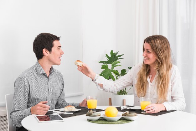 Woman feeding man with small bread