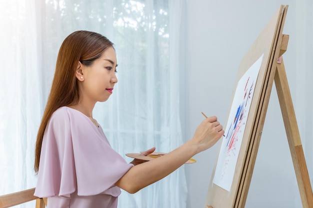 Woman female artist painting picture at home as her hobby