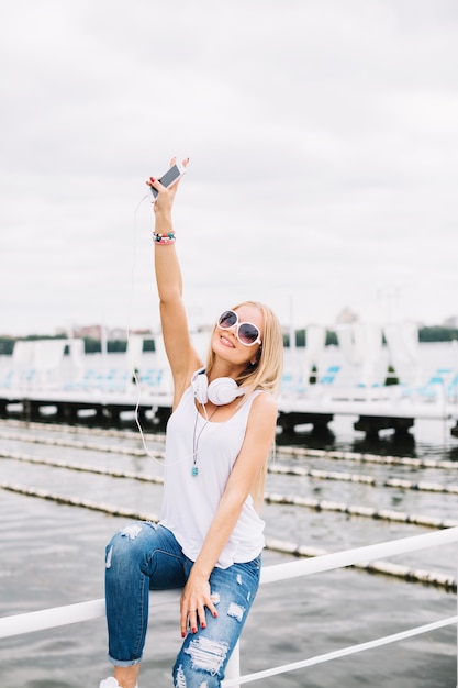 Woman on fence showing peace gesture