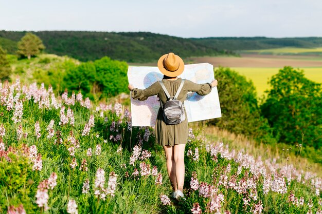 Woman on field looking with big map