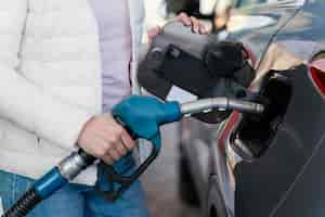 Free photo woman filling up the car at the gas station