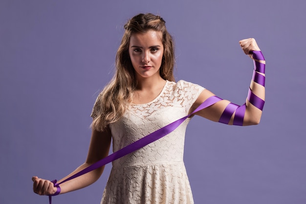 Free Photo woman flexing her arm with ribbon as a sign of strenght