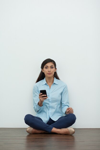 Woman on Floor in Lotus Pose with Smartphone