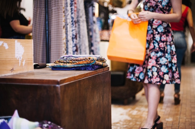 Free photo woman in floral dress with paper bag