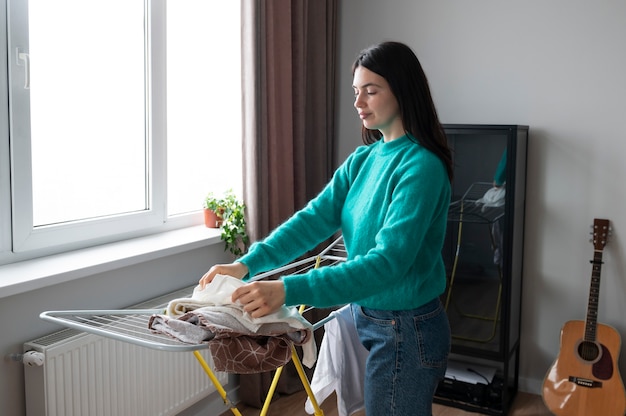 Free photo woman folding towels at home during quarantine