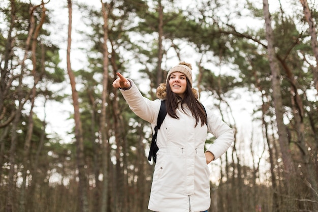 Free Photo woman in forest pointing at distance