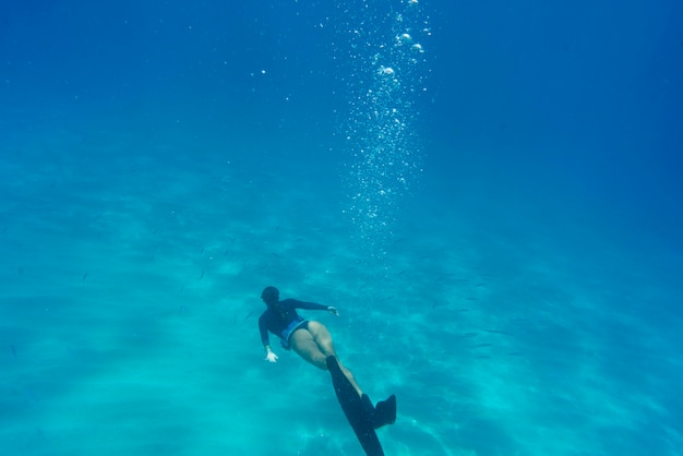 Woman freediving with flippers underwater