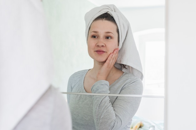 Free Photo woman in front of mirror in bathroom