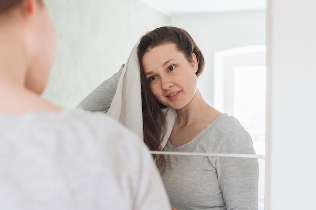 Woman in front of mirror in bathroom