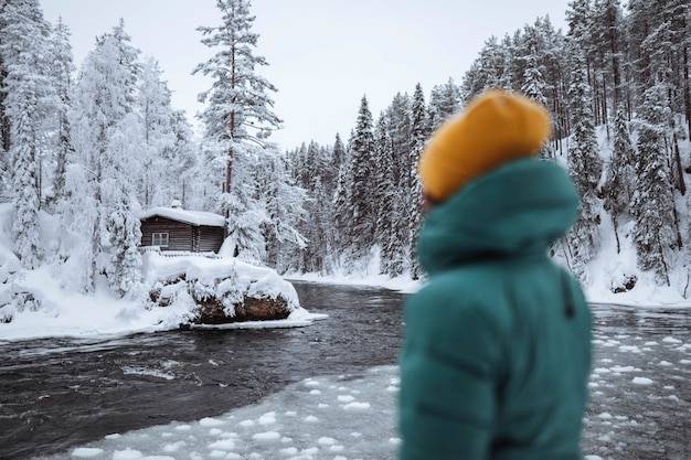 Free photo woman at a frozen river in lapland, finland