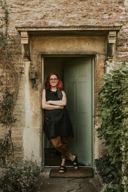 Free photo woman gardener standing by open green door