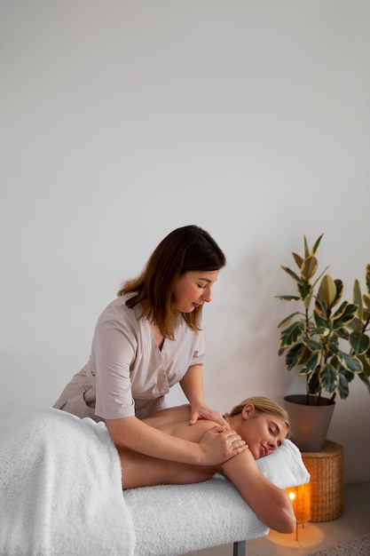 Free Photo woman getting a back massage from masseur