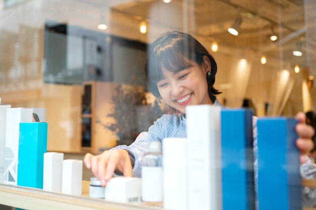 Woman getting the display window of a japanese hairdressers ready