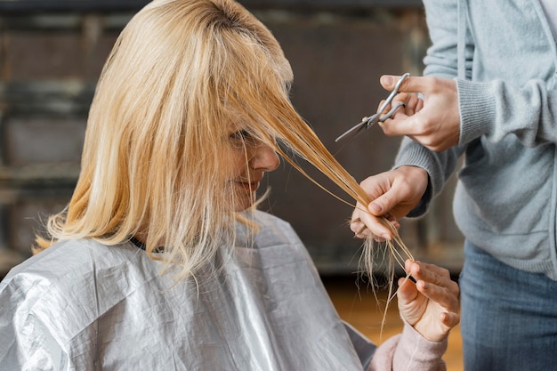 Free photo woman getting her hair cut by hairdresser at home