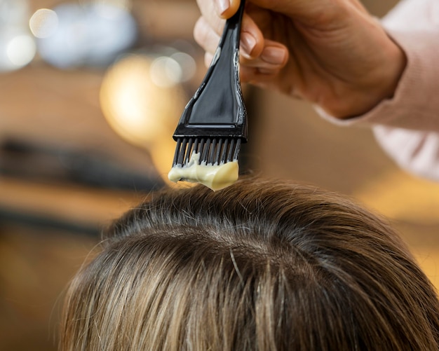 Woman getting her hair dyed at home by hairdresser