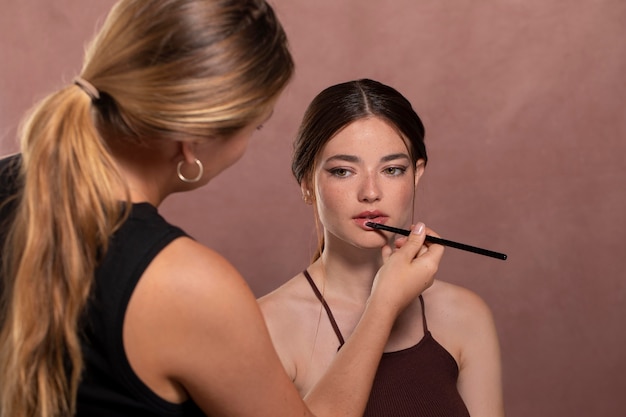 Free photo woman getting her make up done by a professional