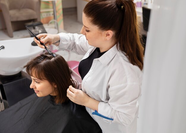 Woman getting treatment at hairdresser shop