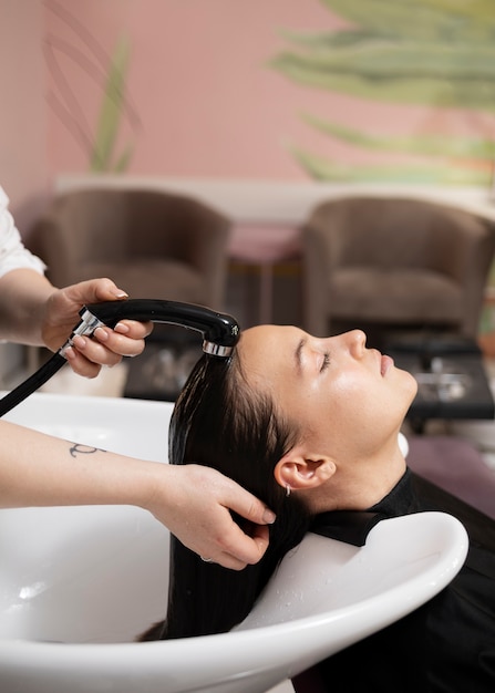 Woman getting treatment at hairdresser shop