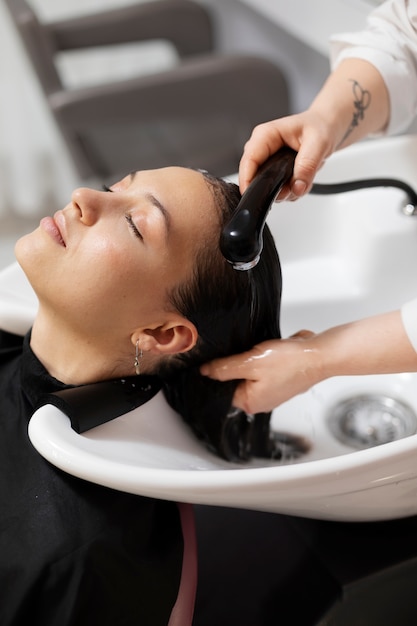 Woman getting treatment at hairdresser shop