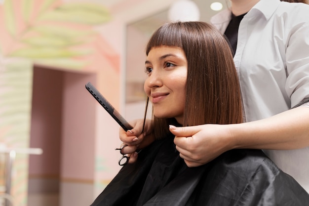 Woman getting treatment at hairdresser shop